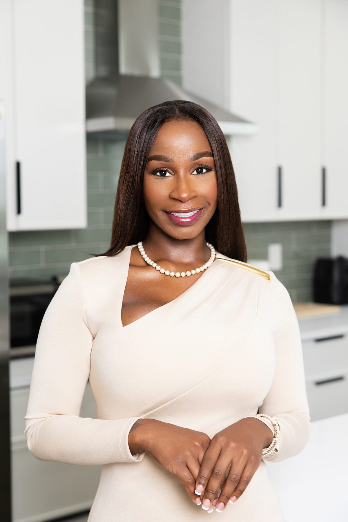 Atlanta realtor in a cream dress photographed in a modern kitchen, personal branding session by ShotByJord