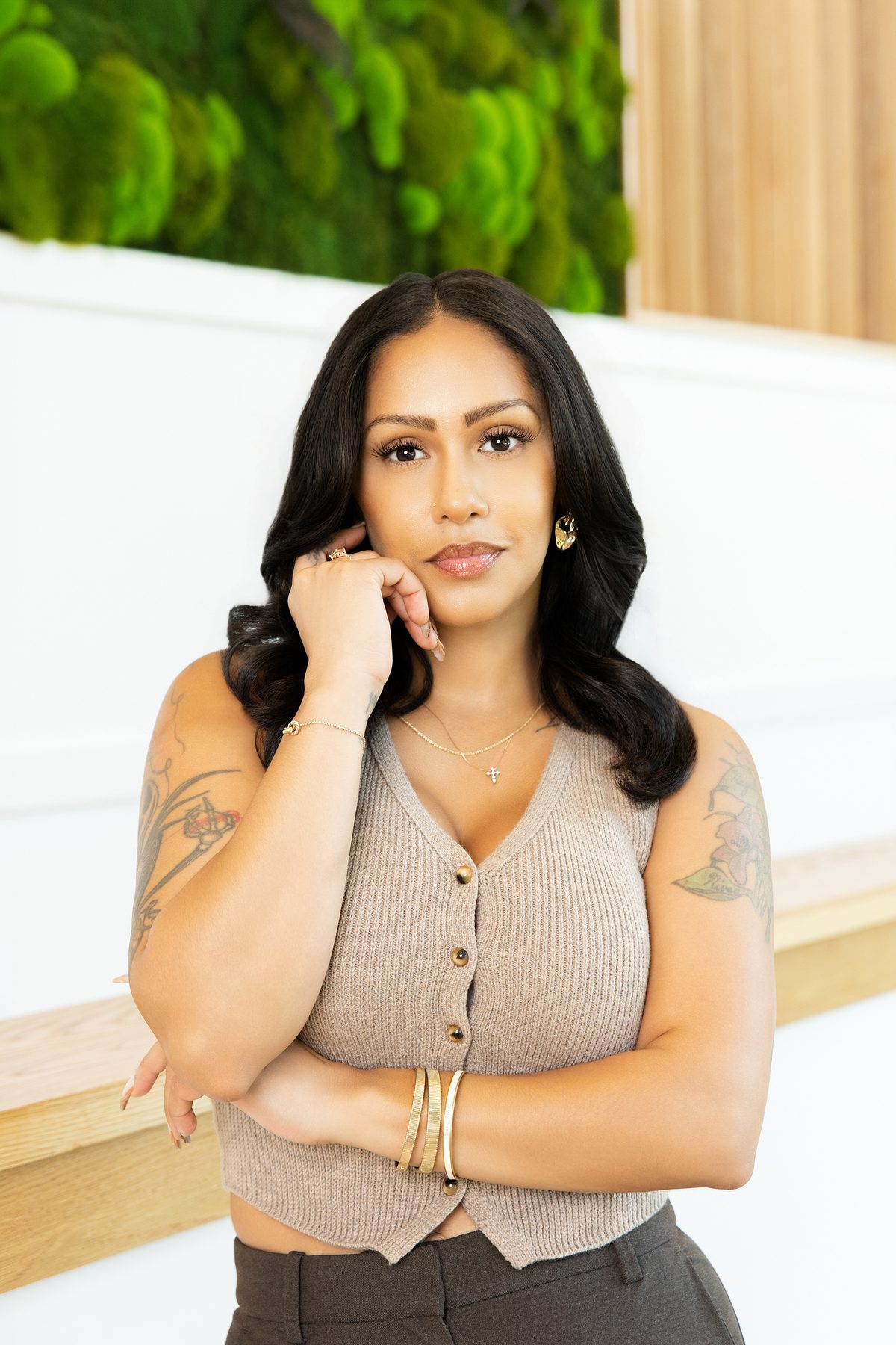 Business owner in a knit top with a hand to her chin, branding portrait by ShotByJord