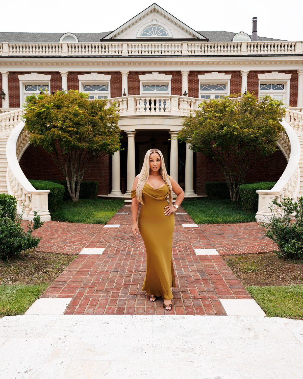 Atlanta realtor in a gold gown photographed in front of a luxury estate, personal branding photo by ShotByJord